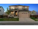 Charming two-story home boasts a 2-car garage, stone accents, and a manicured lawn at 12264 Olive Way, Thornton, CO 80602