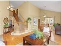 Inviting living room with hardwood floors, vaulted ceiling, staircase, and a large picture window at 1898 Wilson Cir, Erie, CO 80516