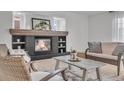 Cozy living room showcasing a stone fireplace, plush seating, neutral decor, and lots of natural light at 1385 Candleglow St, Castle Rock, CO 80109