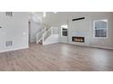 Bright living room with fireplace, modern white staircase, and wood-look floors at 24661 E 33Rd Dr, Aurora, CO 80019