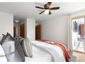 Comfortable bedroom featuring a ceiling fan and sliding glass door to a balcony with outdoor furniture at 1200 N Emerson St # 205, Denver, CO 80218