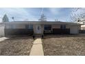 Single-story home with brick accents, a well-maintained lawn and a welcoming walkway at 1469 S Reed St, Lakewood, CO 80232