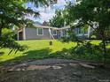 This exterior shot showcases the property's lush lawn and mature trees at 2707 S Richfield St, Aurora, CO 80013