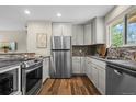 Modern kitchen features stainless steel appliances, granite countertops, and mosaic tile backsplash at 6147 Dunraven St, Golden, CO 80403
