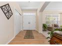 Bright foyer with hardwood floors, closet, double doors, and view of living room at 556 Rachael Pl, Castle Pines, CO 80108