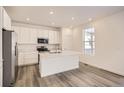 Modern kitchen featuring white cabinets, an island, and stainless steel appliances at 5581 Wisteria Ave, Firestone, CO 80504