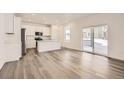 Bright kitchen with white cabinets, an island, and sliding glass doors at 5581 Wisteria Ave, Firestone, CO 80504