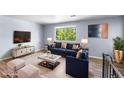 A staged living room with hardwood floors, bright window and stylish furniture at 1155 S Fairplay Cir # D, Aurora, CO 80012