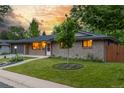 Beautiful home with well-manicured front yard featuring a young tree and lush green grass at 2644 S Krameria St, Denver, CO 80222