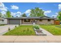 Charming brick home with a well-manicured lawn, sidewalk, and two car garage at 2644 S Krameria St, Denver, CO 80222
