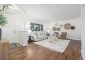 Bright living room with wood floors, neutral furniture, and large windows at 2644 S Krameria St, Denver, CO 80222