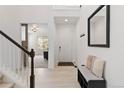 Bright and airy foyer featuring a staircase, a decorative mirror, and a stylish bench with ample storage at 1369 E Witherspoon Dr, Elizabeth, CO 80107