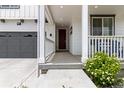 Inviting front porch with a cozy seating area, complemented by lush landscaping and a modern front door at 1369 E Witherspoon Dr, Elizabeth, CO 80107