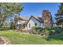 A charming home featuring a stone chimney, complemented by well-maintained landscaping at 6145 S Perry Park Rd, Sedalia, CO 80135