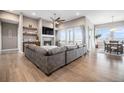 Spacious living room featuring hardwood floors, a ceiling fan, and a stone fireplace at 10145 Deerfield St, Firestone, CO 80504