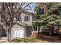 Beautiful 2-story home with an attached garage, blue front door and established trees at 6431 Freeport Dr, Highlands Ranch, CO 80130