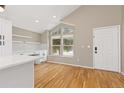 Bright kitchen and dining room features white cabinets, lots of light and hardwood floors at 6431 Freeport Dr, Highlands Ranch, CO 80130