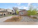 Home featuring a brick facade, driveway, and low-maintenance rock landscaping at 12606 Fairfax St, Thornton, CO 80241