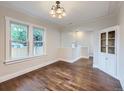 Sunlit dining room with hardwood floors features stylish lighting and built-in cabinet at 1351 Brentwood St, Lakewood, CO 80214