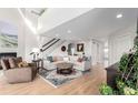 Bright living room with hardwood floors, a fireplace, a staircase, and an oversized sectional sofa at 5271 N Mesa Dr, Castle Rock, CO 80108