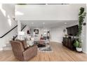 Bright living room with hardwood floors, a fireplace, a staircase, and an oversized sectional sofa at 5271 N Mesa Dr, Castle Rock, CO 80108