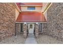 Front entrance featuring brick pillars and red metal roof at 14720 E Kentucky Dr # 625, Aurora, CO 80012