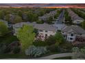 Aerial view of suburban neighborhood, showing home with manicured lawn, mature trees and twilight sky at 6095 S Oswego St, Greenwood Village, CO 80111