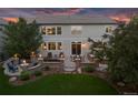 Beautiful backyard at dusk featuring a patio, fire pit, lush lawn, and mature trees, perfect for evening gatherings at 6095 S Oswego St, Greenwood Village, CO 80111