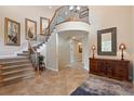 Grand foyer features soaring ceilings, staircase with iron railings, and elegant tile flooring at 6095 S Oswego St, Greenwood Village, CO 80111