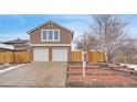 Two-story home features a two-car garage, brick accents, and landscaped front yard at 8799 Independence Way, Arvada, CO 80005