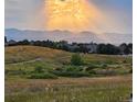 Scenic backyard view showcasing rolling hills and distant mountains under a dramatic sky at 10258 Pennington Ln, Highlands Ranch, CO 80126