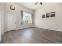 Bright living room featuring soaring ceilings, wood-look floors, and a large window with charming curtains at 1732 Aspen Meadows Cir, Federal Heights, CO 80260