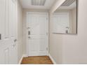 Clean entryway with a white door, neutral walls, and a mirrored accent, maximizing light and space at 2700 E Cherry Creek South Dr # 220, Denver, CO 80209