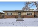 Charming single-story brick home with a cozy entrance and snow-covered front yard at 3420 Tennyson St # 105, Denver, CO 80212