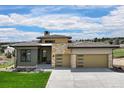Modern home with a three-car garage, stone accents, and pristine landscaping at 6196 Oxford Peak Ln, Castle Rock, CO 80108