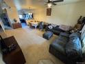 Inviting living room with a gray couch, dining area, ceiling fan and neutral-toned carpet at 2874 Rose Hill St, Strasburg, CO 80136