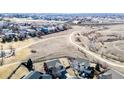 Wide aerial view showcasing the home's location, adjacent fields, and surrounding neighborhood at 2954 E 108Th Dr, Northglenn, CO 80233