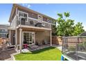 Cozy backyard features artificial turf, a patio, and a balcony; perfect for outdoor relaxation and play at 10560 Waco St, Commerce City, CO 80022