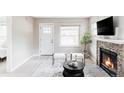 Cozy living room featuring a stone fireplace, neutral decor, and stylish furnishings at 4209 S Bannock St, Englewood, CO 80110