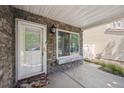 Inviting front porch with stone accents, a window seat, decorative lighting, and a welcoming entrance at 4435 Andes Ct, Denver, CO 80249