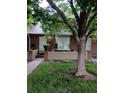 Brick townhome featuring a bay window, neat landscaping, and a shade tree at 3300 W Florida Ave # 51, Denver, CO 80219