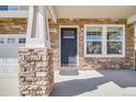Inviting front porch with stone detailing, white columns, and a view of the home's entrance at 19294 E Warren Pl, Aurora, CO 80013