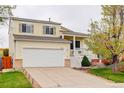 Charming yellow two-story home featuring a two-car garage, manicured lawn and mature trees at 20626 Willowbend Ln, Parker, CO 80138