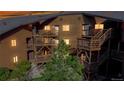 Exterior view of brown building featuring multiple balconies, staircases and mature landscaping at dusk at 6110 Habitat Dr # 2, Boulder, CO 80301