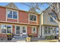 Charming townhouse with a red and beige exterior and well-maintained landscaping at 9747 W Cornell Pl, Lakewood, CO 80227