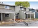 Two-story townhome showcasing a covered carport, grey siding and inviting front entrance with rock landscaping at 2976 Eagle Way, Boulder, CO 80301