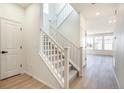 Bright entryway with a staircase featuring white railings, leading to a spacious and naturally lit upstairs area at 2237 Garden Ave, Brighton, CO 80601