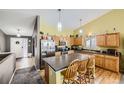 Bright kitchen featuring wood cabinets, stainless steel appliances, and a functional kitchen island at 11462 Iola St, Commerce City, CO 80640