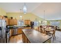 Open concept kitchen with a large island and stylish pendant lighting, open to the dining and living room at 11462 Iola St, Commerce City, CO 80640