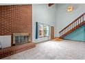 Bright living room with a brick fireplace, staircase and large windows providing natural light and views at 3300 W Florida Ave # 36, Denver, CO 80219